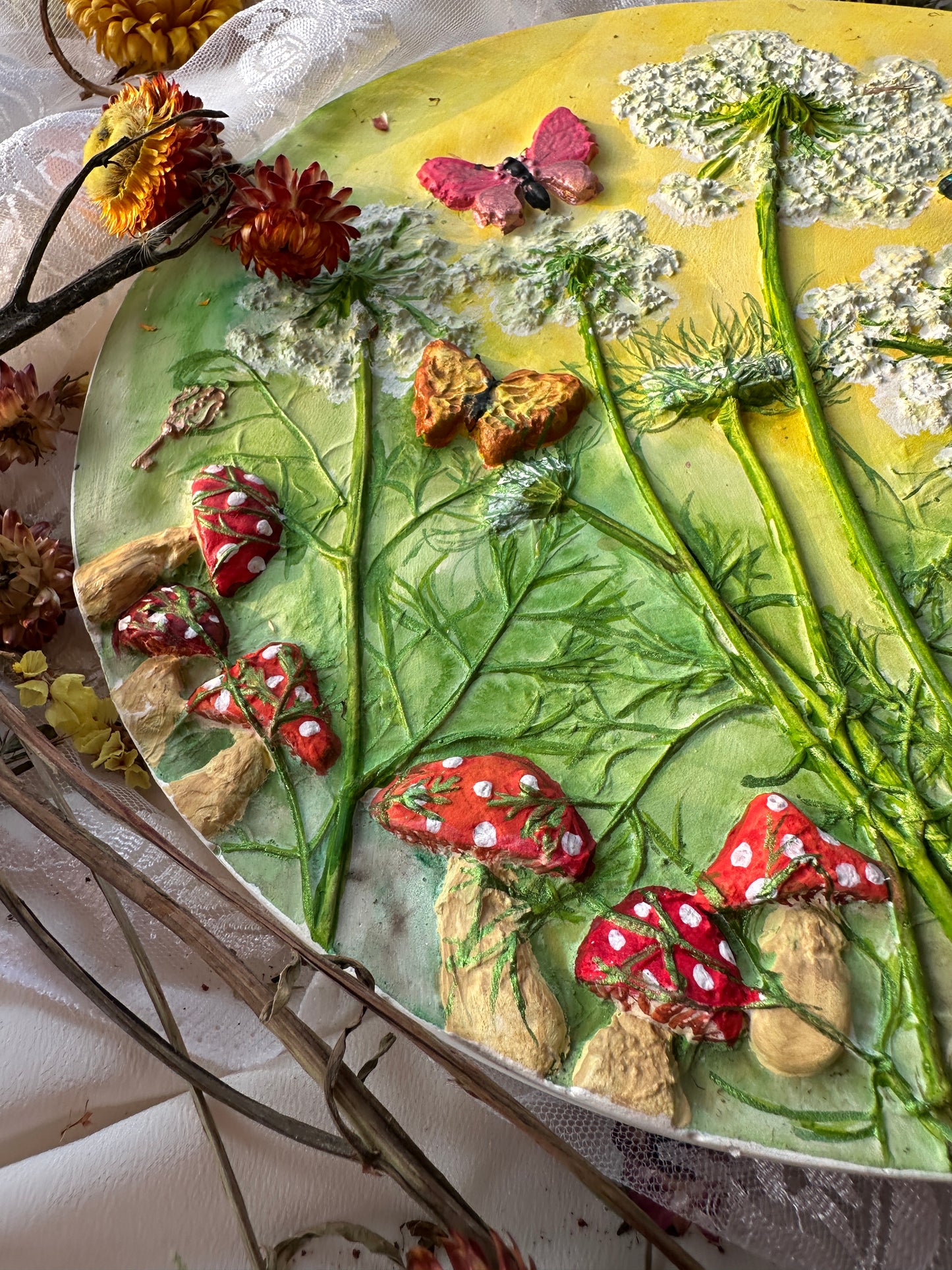 Plaster of Paris art tablet featuring mushrooms nestled among whimsical weeds